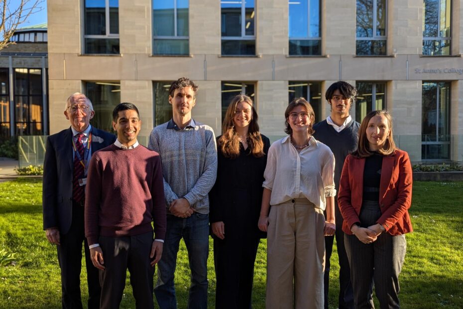 The competition finalists and judges stand in St Anne's college, in early spring sunshine.